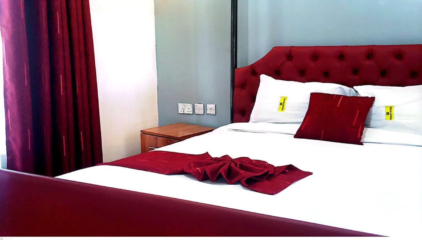 Toque Hotel branded guest room with burgundy headboard in Ngara Nairobi